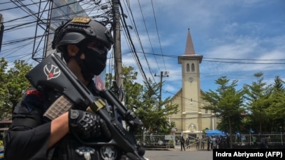 Polisi berjaga di luar gereja pasca ledakan di Makassar pada 28 Maret 2021. (Foto: AFP/Indra Abriyanto)