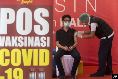 Seorang petugas kesehatan menerima suntikan vaksin Covid-19 di sebuah rumah sakit di Bali, pada Kamis, 14 Januari 2021. (Foto: AP)