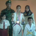 Windiyana Putri Oktavia foto bersama dengan kedua orang tuanya serta dua adiknya dengan sejumlah piala yang diraihnya di cabang olahraga bela diri takwondo. FOTO : AHMAD SUGENG LAKSONO