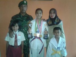 Windiyana Putri Oktavia foto bersama dengan kedua orang tuanya serta dua adiknya dengan sejumlah piala yang diraihnya di cabang olahraga bela diri takwondo. FOTO : AHMAD SUGENG LAKSONO