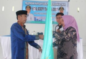 Wakil Bupati Koltim Hj Andi Merya Nur menyerahkan pataka kepada ketua tim rombongan Kafilah MTQ dan disaksikan Asisten III Syamsul Madjid. FOTO : JUSRAN