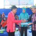 Bupati Kolaka Timur H Tony Herbiansyah menyehakan akte lahir murid SD 1 Lalolae melalui kepala UPTD Dikmudora Lalolae.FOTO : JUSRAN