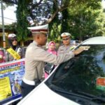 Kasat lantas Polres Bantaeng AKP Muh Tamrin saat memasang stiker Kamseltibcar di salah satu mobil warga. FOTO : SYAMSUDDIN