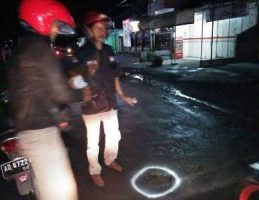 Aksi kemanusian Komunitas ICS dengan melakukan pengetan atai menandai jalan berlubang dengan Cat warna putih. FOTO : AGUNG NUGROHO