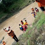Tim SAR bersama warga saat menyusuri sungai untuk melakukan pencarian korban yang terseret arus sungai. FOTO : BISMA SURYA KURNIAWAN