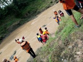 Tim SAR bersama warga saat menyusuri sungai untuk melakukan pencarian korban yang terseret arus sungai. FOTO : BISMA SURYA KURNIAWAN