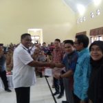 Ketua KIP Aceh Singkil Yarwin Adi Dharma menyerahkan berkas berita acara, kepada bupati Aceh Singkil terpilih Dulmusrid Kamis(6/4) di gedung serbaguna pulosarok. FOTO : MAN