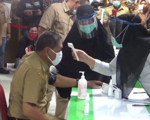 Pengecekan suhu oleh dokter sebelum penyuntikan vaksin