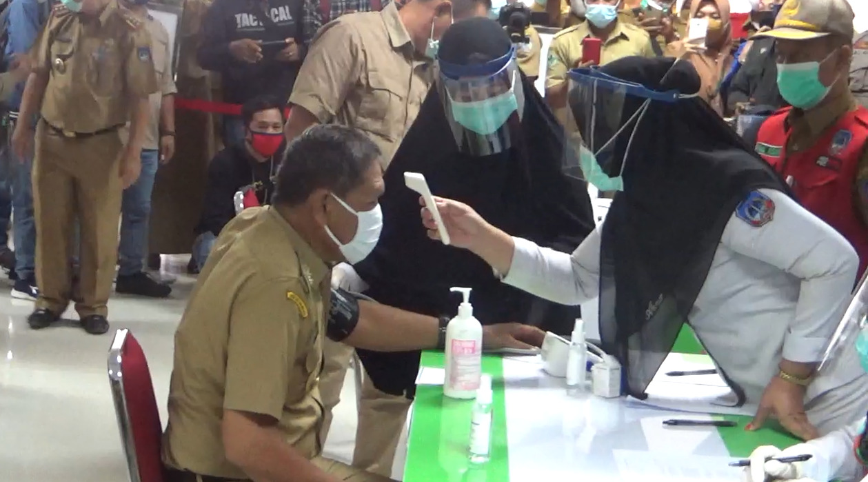 Pengecekan suhu oleh dokter sebelum penyuntikan vaksin