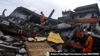 Para petugas SAR memeriksa bangunan yang roboh akibat guncangan gempa di Mamuju, Sulawesi Barat, Sabtu, 16 Januari 2021. (Foto: Antara Foto/Sigid Kurniawan via Reuters)
