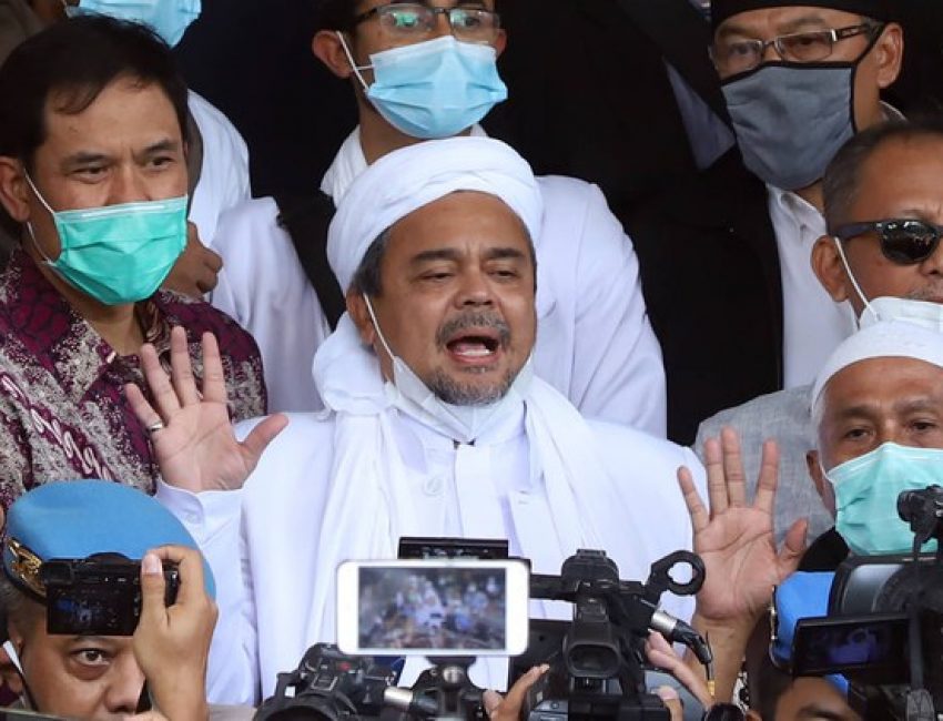 Dalam foto tertanggal 12 December 2020 ini, pimpinan Front Pembela Islam, Muhammad Rizieq Shihab, dikelilingi para pendukungnya ketika datang ke Mabes Polri di Jakarta, setelah beberapa kali ia tidak memenuhi panggilan polisi atas dugaan pelanggaran terhadap protokol kesehatan penanggulangan COVID-19 terkait sejumlah kerumunan besar dalam kegiatannya. Photo: BenarNews