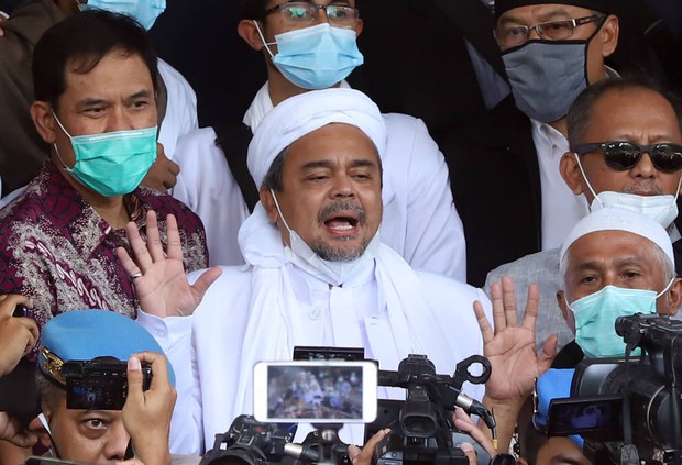 Dalam foto tertanggal 12 December 2020 ini, pimpinan Front Pembela Islam, Muhammad Rizieq Shihab, dikelilingi para pendukungnya ketika datang ke Mabes Polri di Jakarta, setelah beberapa kali ia tidak memenuhi panggilan polisi atas dugaan pelanggaran terhadap protokol kesehatan penanggulangan COVID-19 terkait sejumlah kerumunan besar dalam kegiatannya. Photo: BenarNews
