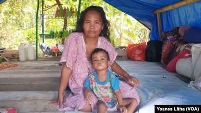 Besaria dan anak balitanya berusia tiga tahun di salah satu tenda terpal di dusun Petakeang, Kecamatan Tapalang, Sulawesi Barat. Jumat (5/1/2021). (Foto: VOA/Yoanes Litha)