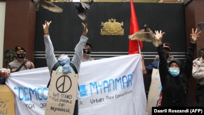 Sejumlah pengunjuk rasa melepaskan burung-burung merpati dalam demo memprotes kudeta militer di Myanmar, di luar Kedutaan Besar Myanmar di Jakarta, Jumat, 5 Februari 2021. (Foto: Dasril Roszandi/AFP)