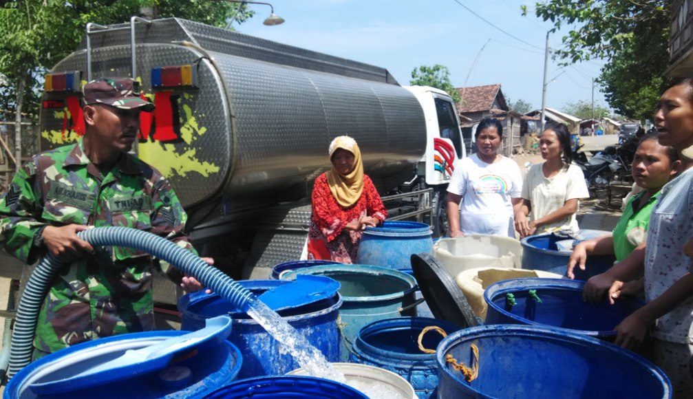Anggota TNI saat membagikan air kepada Warga RT 3 dan RT 5 Desa Kedung Malang, Kecamatan Kedung, Kabupaten jepara. FOTO : DSW
