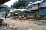 Warga Lorong Lasolo membersihkan rumahnya pasca banjir pagi tadi. FOTO ; ONNO