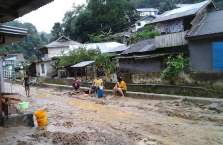 Warga Lorong Lasolo membersihkan rumahnya pasca banjir pagi tadi. FOTO ; ONNO