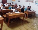 Murid SD Negeri 2 Mandonga tetap melangsungkan Ujian Akhir semester (UAS) meski ruangan kelas masuk air. FOTO : ILHAM