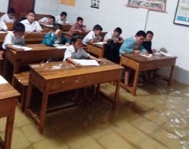 Murid SD Negeri 2 Mandonga tetap melangsungkan Ujian Akhir semester (UAS) meski ruangan kelas masuk air. FOTO : ILHAM