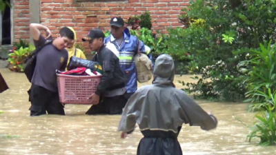 Anggota Polisi saat membantu warga mengevakuasi barang di tempat ketinggian akibat banjir. FOTO : FA