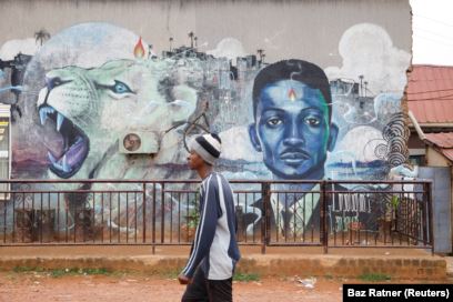 Seorang pria berjalan melewati grafiti calon presiden oposisi Uganda Robert Kyagulanyi, juga dikenal sebagai Anggur Bobi, di Kampala, Uganda 17 Januari 2021. (Foto: REUTERS/Baz Ratner)