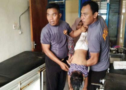 Tampak Kapolsek Iptu Suis Mail (kiri) bersama anggotanya melakukan pertolongan dengan kaki korban diatas kepala dibawah agar air dalam perut korban bisa keluar. FOTO : SUDIRMAN