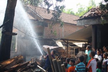petugas kebakaran saat menjinakkan kobaran api yang membakar gudang kotak buha di Welahan. FOTO : DSW