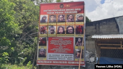 Baliho Daftar Pencarian Orang (DPO) Polisi yang memuat nama dan foto anggota kelompok Mujahidin Indonesia Timur (MIT) yang terpajang di Desa Tongoa, Kecamatan Palolo, Kabupaten Sigi, Sulawesi Tengah. (Foto: Yoanes Litha/VOA)