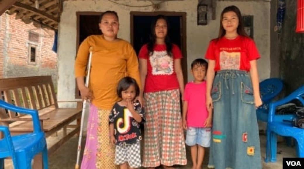Rasminah (kiri) bersama empat dari lima anaknya di depan rumah mereka di Indramayu, Jawa Barat, Minggu, 7 Maret 2021.