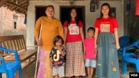 Rasminah (kiri) bersama empat dari lima anaknya di depan rumah mereka di Indramayu, Jawa Barat, Minggu, 7 Maret 2021.