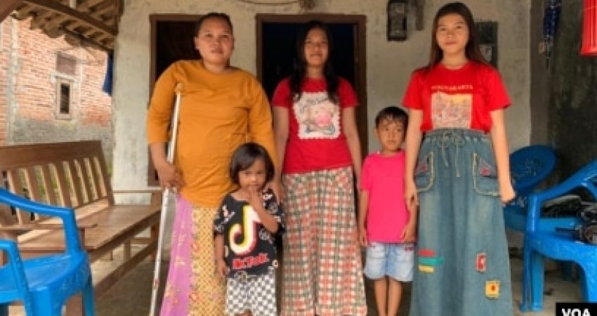 Rasminah (kiri) bersama empat dari lima anaknya di depan rumah mereka di Indramayu, Jawa Barat, Minggu, 7 Maret 2021.