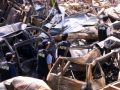 Polisi forensik berjalan melewati mobil-mobil yang hancur di dekat lokasi ledakan bom 12 Oktober 2002 di Kuta, Bali, 18 Oktober 2002. Tiga tersangka yang diduga terlibat pemboman di Indonesia antara tahun 2002-2003 akan diadili pengadilan militer AS. (Foto: Reuters)