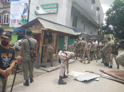 satpol PP saat membongkar kios warga yang dianggap melanggar perda. FOTO : FT