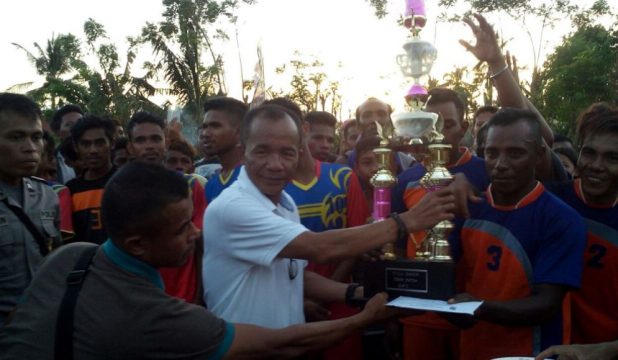 Sekretaris Daerah Kabupaten Muna Nurdin Pamone (baju putih) saat menyerahkan tropi dan uang pembinaan kepada kapten tim futsal Desa Pure akhir pekan lalu. FOTO : LA ODE AWALUDDIN