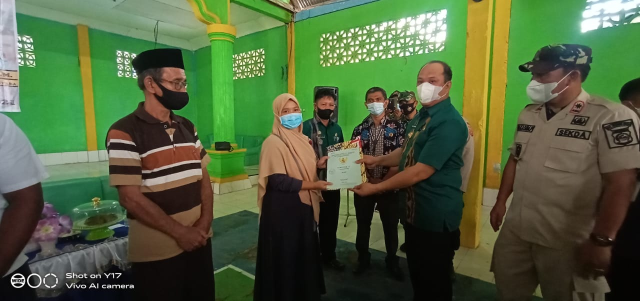 Bupati Konawe Utara Dr.Ir. H. Ruksamin, ST., M.Si., IPM., ASEAN.Eng., memberikan Sertifikat tanah secara simbolis