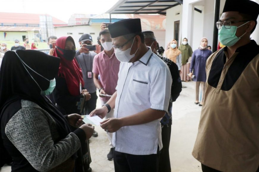 Wali kota kendari, saat membagikan bantuan kepada masyarakat