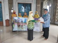 Kepala SD Muhammadiyah Kriyan Muntiasih ( kiri) memberikan bantuan kepada ketua PRM Dorang