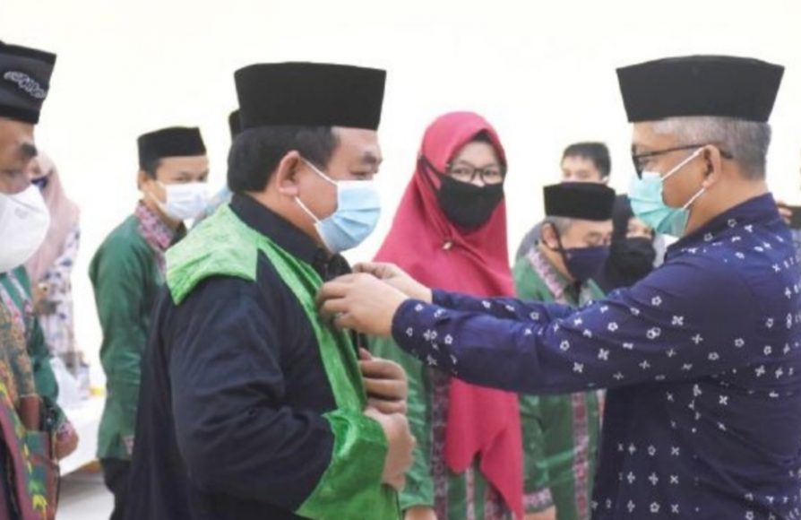 Wabup Konawe saat memakaikan baju toga kepada Dewan Hakim STQH Konawe