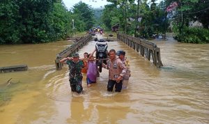 Polsek Wawonii Giat Membantu Masyarakat Menyebrangi Jembatan Terendam Banjir
