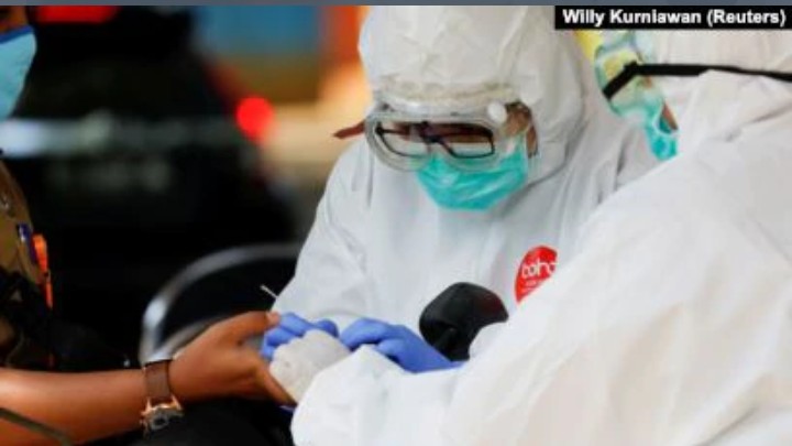 Petugas kesehatan yang mengenakan alat pelindung mengambil sampel darah untuk menguji seorang pria terhadap virus corona (COVID-19) di Bogor, Jawa Barat, 7 April 2020. (Foto: Reuters/Willy Kurniawan)