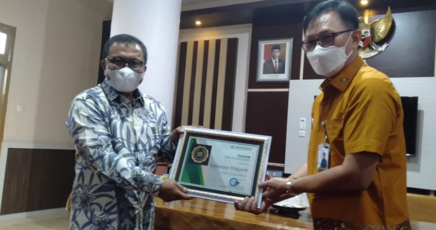 Bupati Wakatobi Arhawi saat menerima Piagam BPJS dari Deputi Direksi Wilayah Sulselbartramal) Dr. Beno Herman, di Wakatobi, Jum'at (25/06/2021).