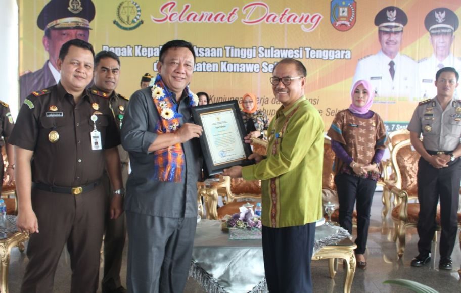 Bupati Konsel H Surunudin Dangga Saat Menyerahkan Piagam TP4D Kepada Kepala Kejaksaan Tinggi Sultra Azhari, SH MH FOTO : HUMAS PEMDA KONSEL