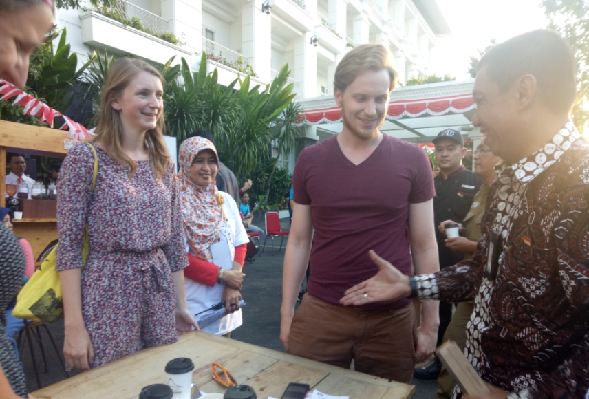 Walikota Yogyakarta Haryadi Suyuti saat berbincang dengan dua turis di festival kopi FOTO : NADHIR ATTAMIMI