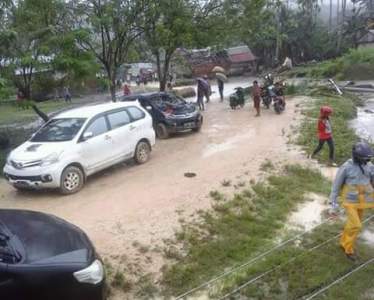 Anggota Polri bersdama warga membuat jalan alternatif yang putus akibat hujan. FOTO : MIRDAT