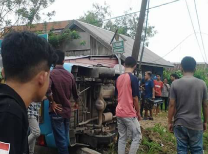 Mobil angkutan umum (Mikrolet) yang terbalik di depan Kampus UHO kendari menjadi tontoan warga. FOTO : ILHAM