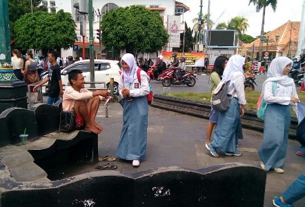 SMA di Yogyakarta merekan kelulusan sekolah dengan melakukan berbagi makanan kepada warga. FOTO : NADHIR