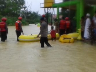 penanggunalangan bencana dari Kepolisian saat membantu warga mengevakuasi barang akibat banjir.  FOTO : ONNO