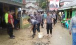 Anggota Kepolisian Polda Sultra membantu warga membersihkan pemukiman warga dari sisa banjir di jalan Lasono Kelurahan Sanua. FOTO : ODEK