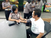 Salah satu warga di kota Yogyakarta saat dilakukan pemeriksaan tekanan darah oleh salah seorang Polwan. FOTO : NADHIR ATTAMIMI