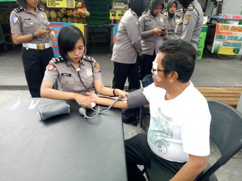 Salah satu warga di kota Yogyakarta saat dilakukan pemeriksaan tekanan darah oleh salah seorang Polwan. FOTO : NADHIR ATTAMIMI